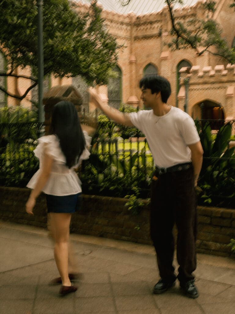 Couple dancing during a romantic downtown Houston anniversary photo session with historic brick architecture and greenery in the background.