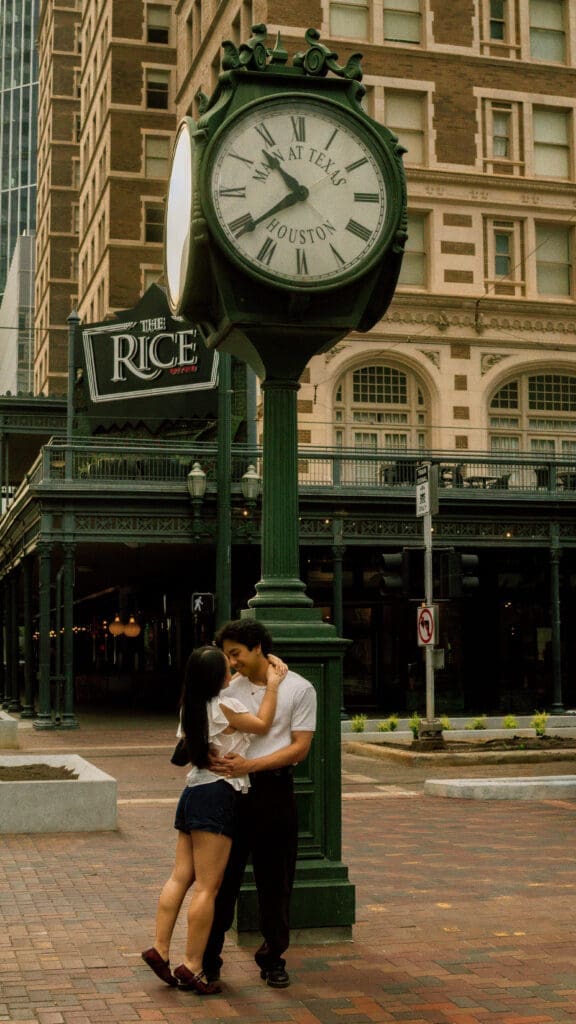 Couple embracing beneath the historic Rice Hotel clock during a romantic downtown Houston anniversary photo session.