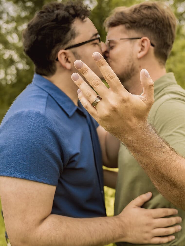 Same-sex couple showing an engagement ring during a romantic engagement session at Mercer Botanic Gardens near Houston, Texas.