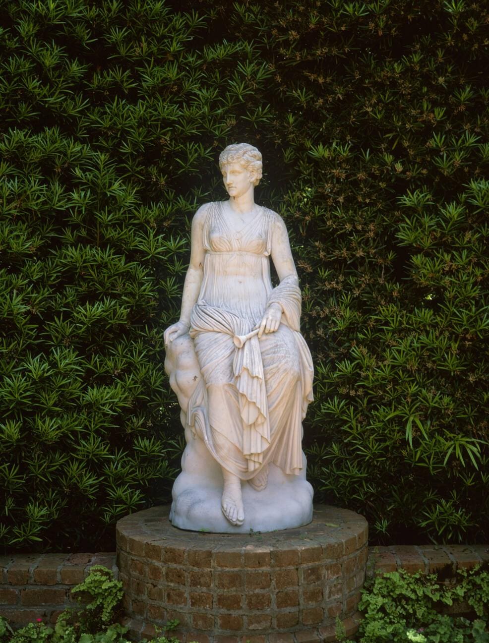 White classical garden statue surrounded by lush greenery at Bayou Bend Collection and Gardens in Houston, Texas.